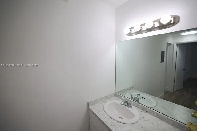 a bathroom with a granite countertop sink and a mirror