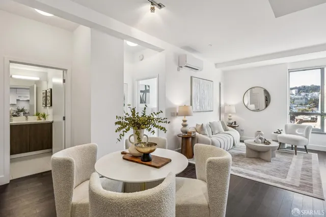 a living room with furniture kitchen view and a mirror