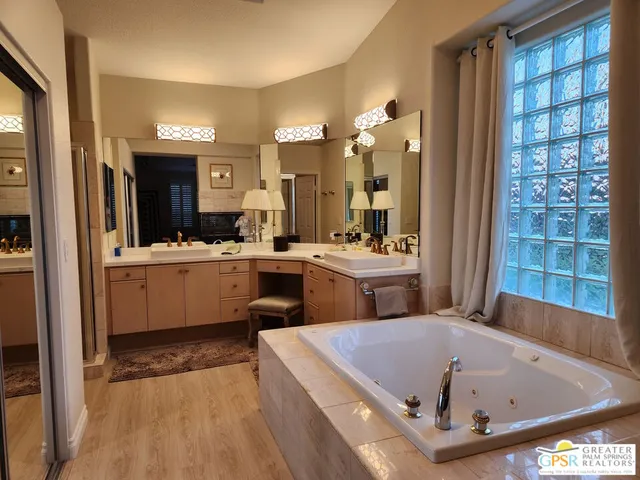 a bathroom with a bath tub a sink and a large mirror