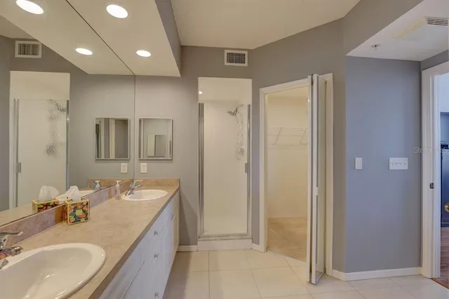 a bathroom with a granite countertop sink shower and a mirror