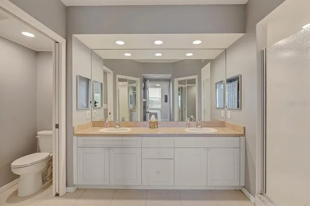 a spacious bathroom with a double vanity sink toilet mirror and double