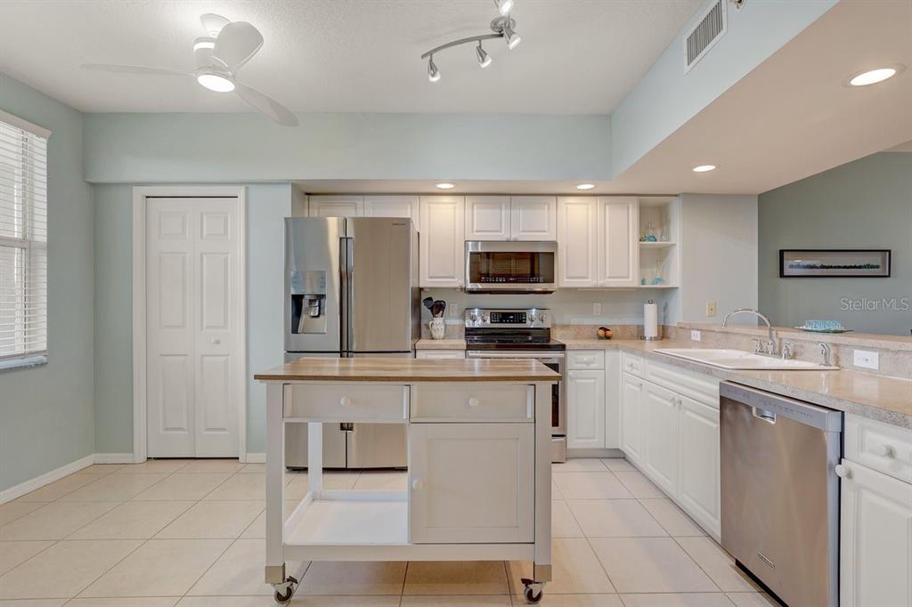 960 Starkey Road, Unit 2405 Largo, FL 33771 - Photo 7 of 31 a kitchen with kitchen island granite countertop appliances cabinets and a sink