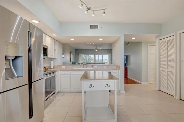 a kitchen with stainless steel appliances kitchen island granite countertop a refrigerator and a stove top oven