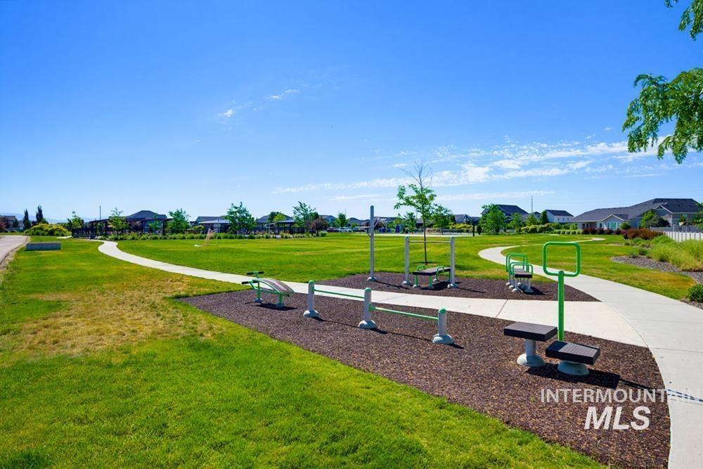 5897 West Riva Capri Street Meridian, ID 83646 - Photo 48 of 50 Outdoor exercise equipment bordered by a paved walking path and expansive green lawn