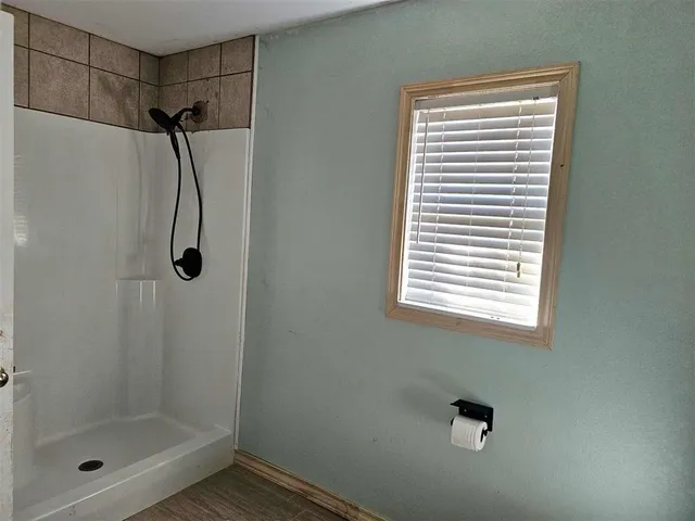 wooden floor in an empty room with a chandelier