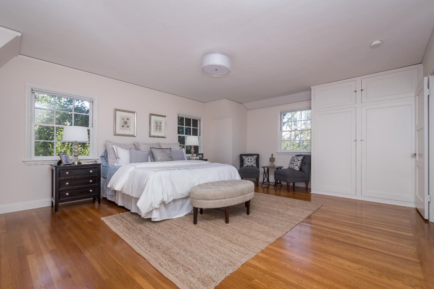515 Warren Road San Mateo, CA 94402 - Photo 14 of 27 a spacious bedroom with a bed and a chandelier