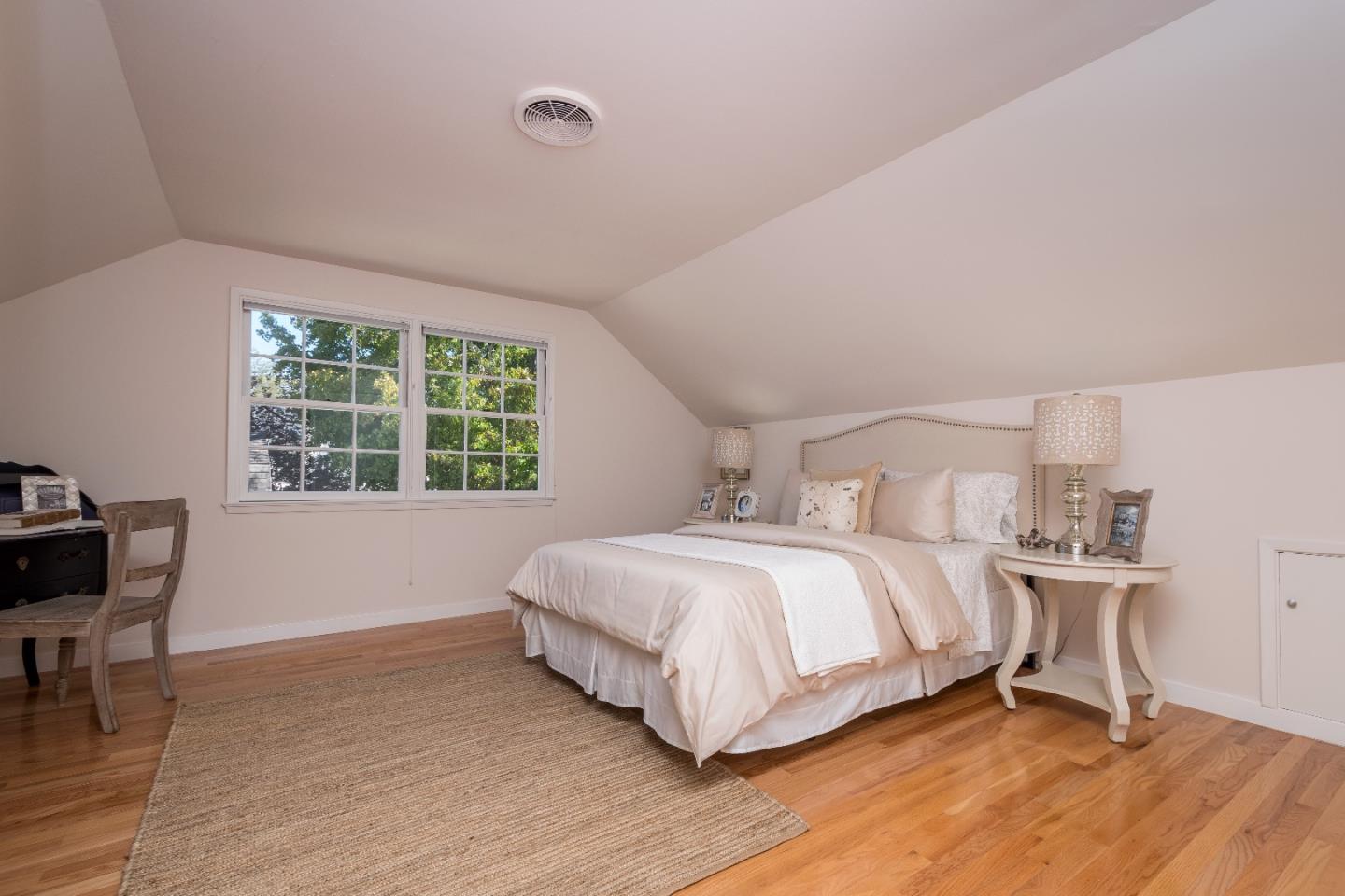 515 Warren Road San Mateo, CA 94402 - Photo 17 of 27 a bedroom with a bed a table and a window