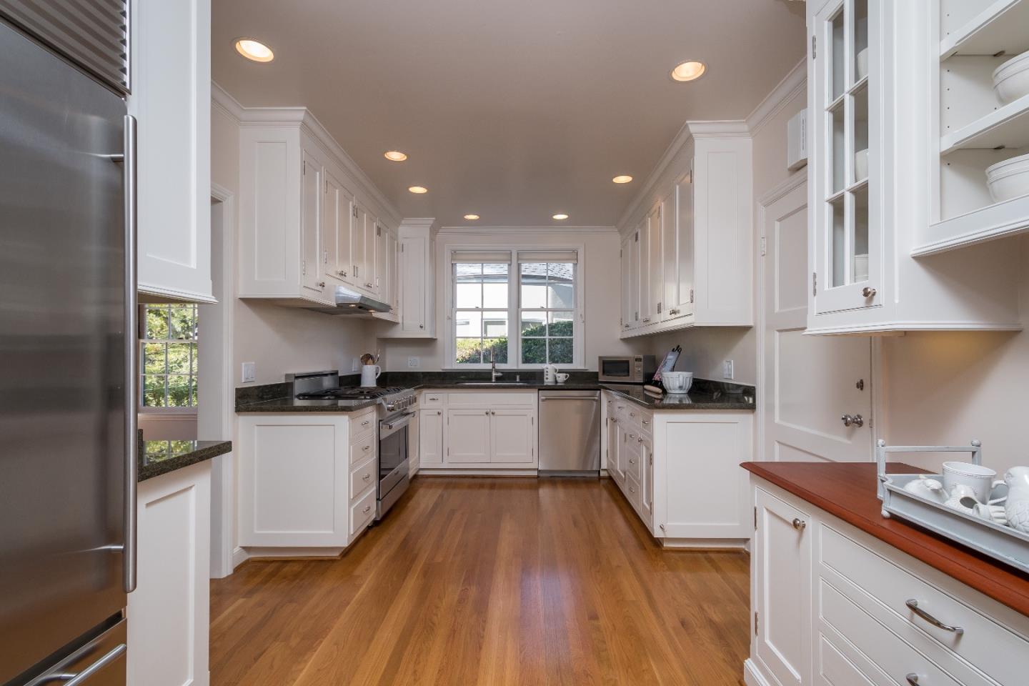 515 Warren Road San Mateo, CA 94402 - Photo 8 of 27 a kitchen with granite countertop a stove top oven a sink a counter space and cabinets