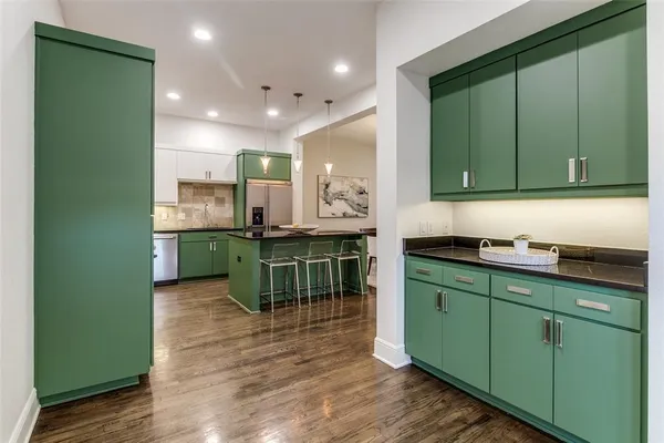 a kitchen with lots of counter and chairs