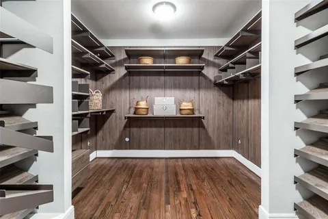 a view of walk in closet with clothes and shoes