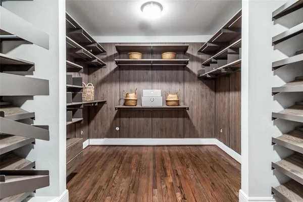 a view of walk in closet with clothes and shoes