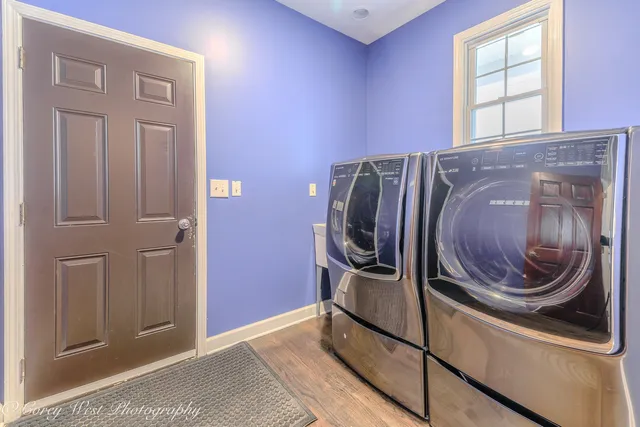 an empty room with chandelier fan and hallway