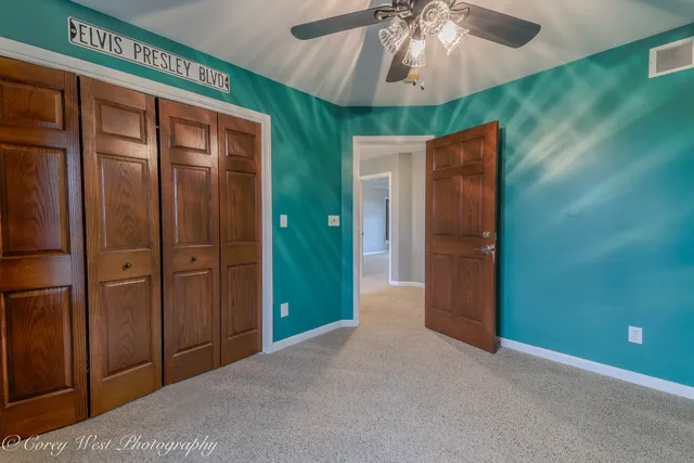 a bedroom with a bed a couch and a chandelier