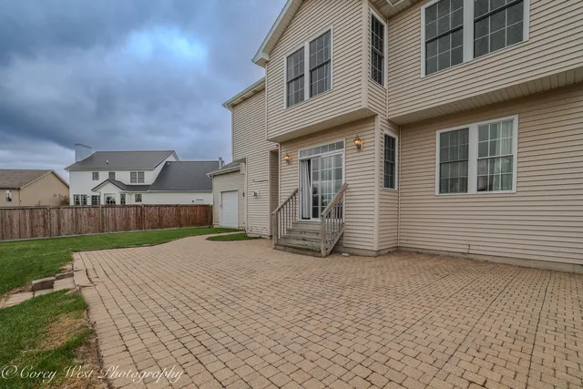 a view of a white house with a small yard and large tree