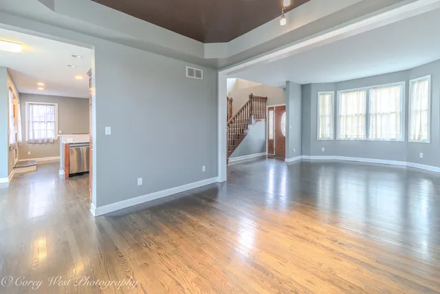 a kitchen with stainless steel appliances granite countertop a sink a stove a refrigerator and island with wooden floor