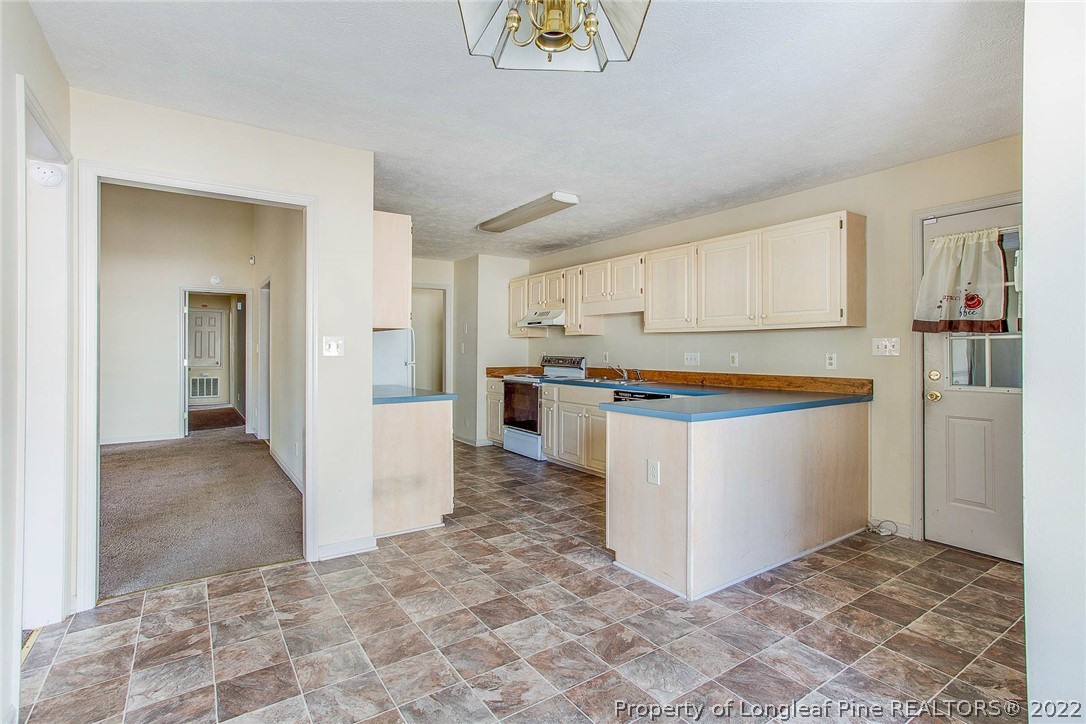 2608 Laurel Lakes Road Fayetteville, NC 28301 - Photo 11 of 32 a kitchen with a refrigerator and a stove top oven