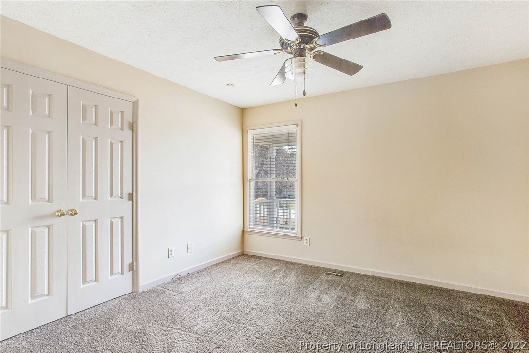 2608 Laurel Lakes Road Fayetteville, NC 28301 - Photo 19 of 32 an empty room with a ceiling fan and a window
