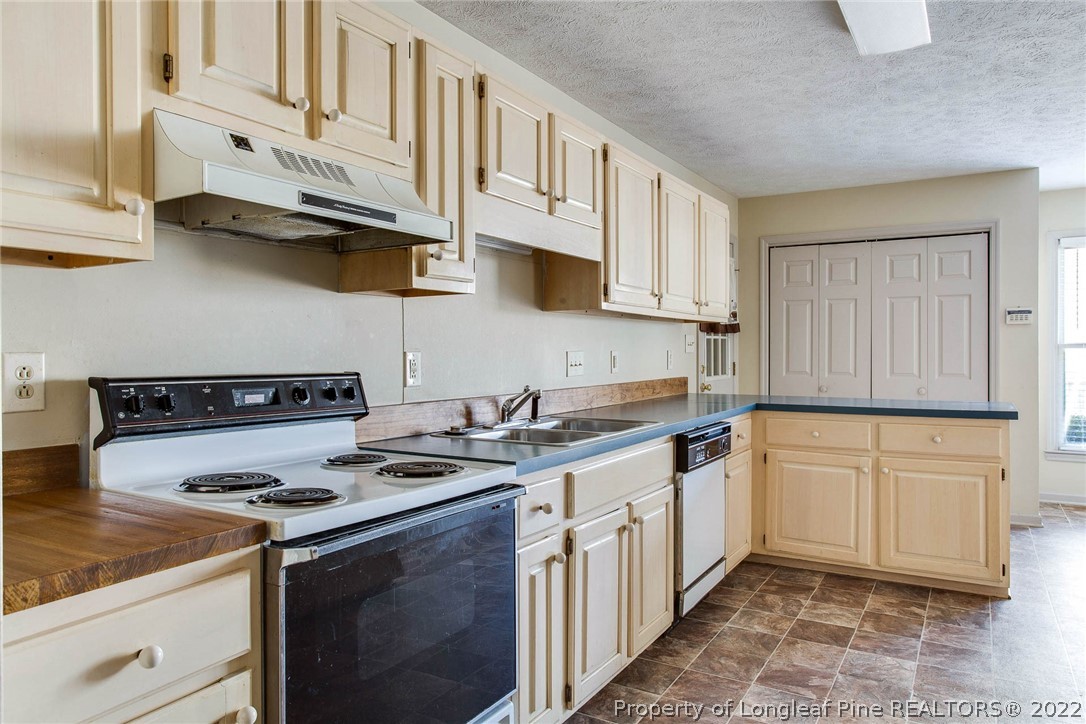 2608 Laurel Lakes Road Fayetteville, NC 28301 - Photo 7 of 32 a kitchen with stainless steel appliances granite countertop a stove a sink and a microwave