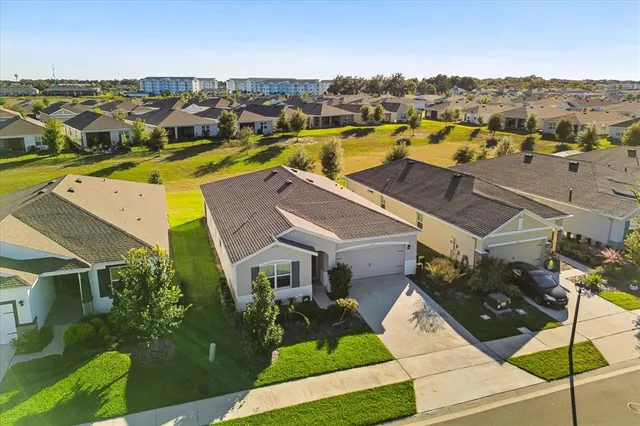 an aerial view of residential houses with outdoor space and parking
