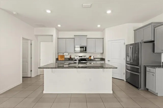 a kitchen with stainless steel appliances granite countertop a refrigerator and a stove