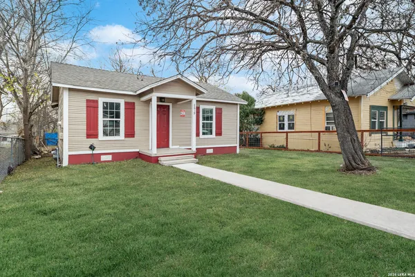 a front view of a house with a yard and trees