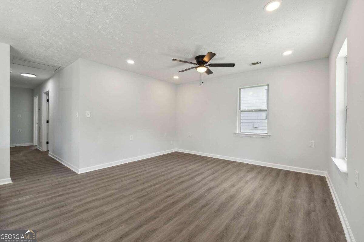823 Humphries Street Southwest Atlanta, GA 30310 - Photo 11 of 22 an empty room with wooden floor and windows
