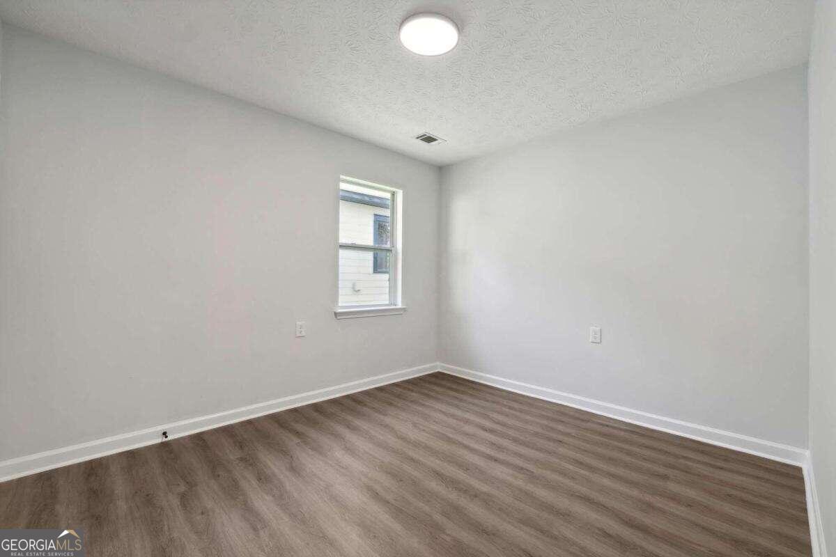 823 Humphries Street Southwest Atlanta, GA 30310 - Photo 12 of 22 an empty room with wooden floor and windows