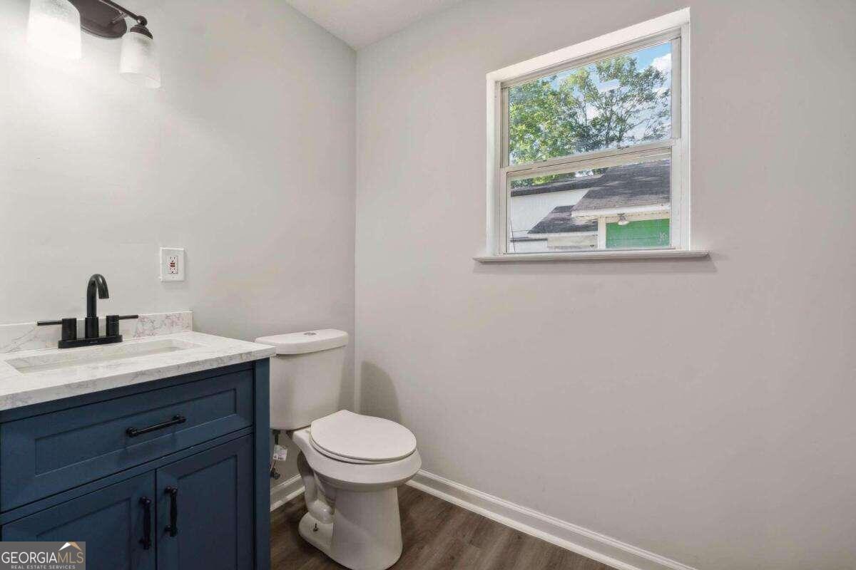 823 Humphries Street Southwest Atlanta, GA 30310 - Photo 15 of 22 a bathroom with a toilet a sink a window and mirror
