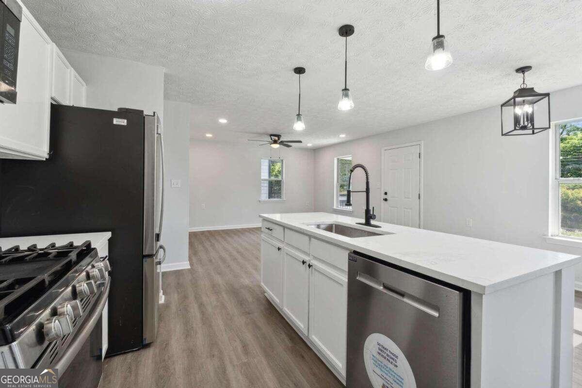 823 Humphries Street Southwest Atlanta, GA 30310 - Photo 6 of 22 a kitchen with a sink stove and wooden floor