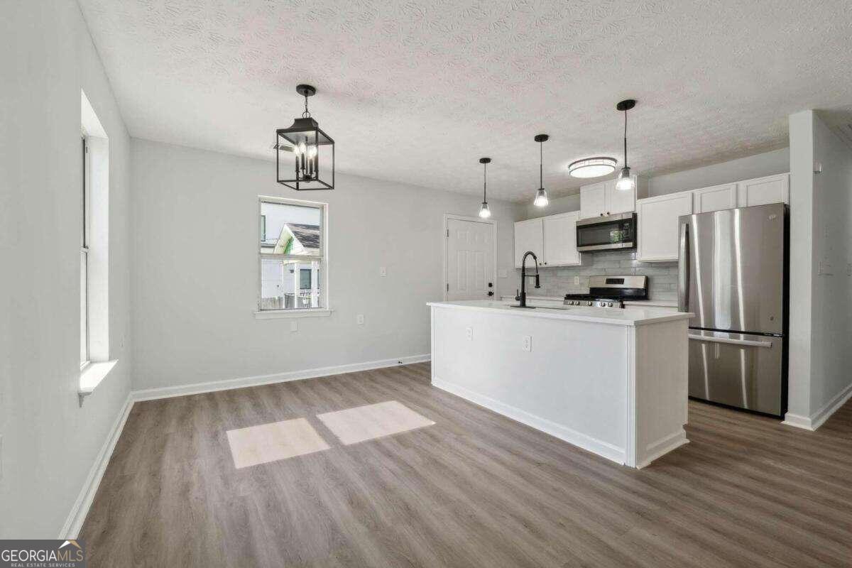 823 Humphries Street Southwest Atlanta, GA 30310 - Photo 8 of 22 a view of kitchen with wooden floor electronic appliances and window