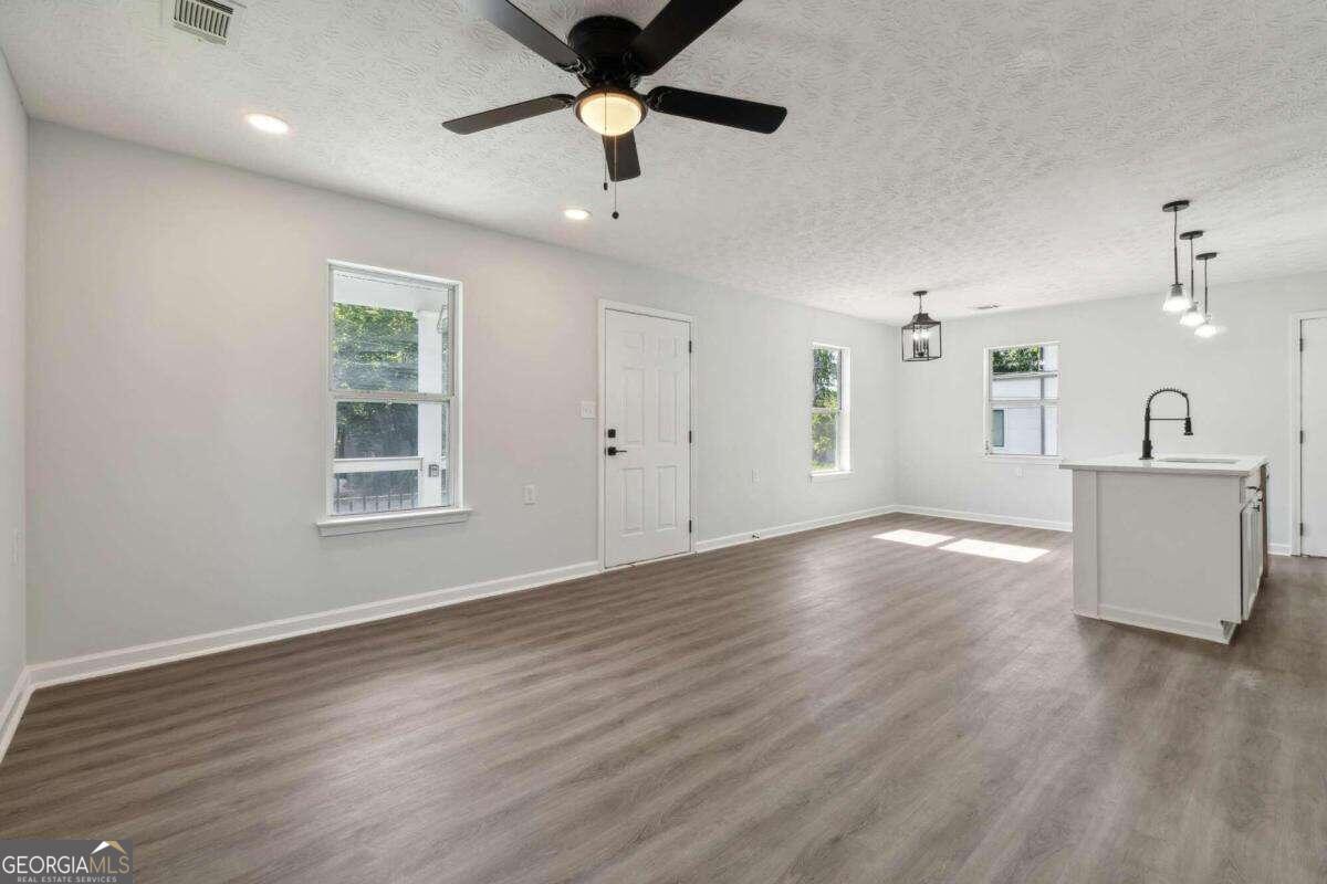 823 Humphries Street Southwest Atlanta, GA 30310 - Photo 10 of 22 an empty room with wooden floor and windows