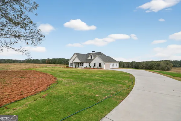 a view of a house with a yard and lake view