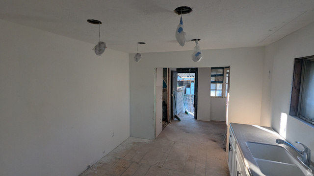 436 Rose Avenue Price, UT 84501 - Photo 10 of 36 Kitchen area featuring white walls, open doorway, recessed lighting pre-install, under-window cabinetry, and an integrated sink with a chrome faucet