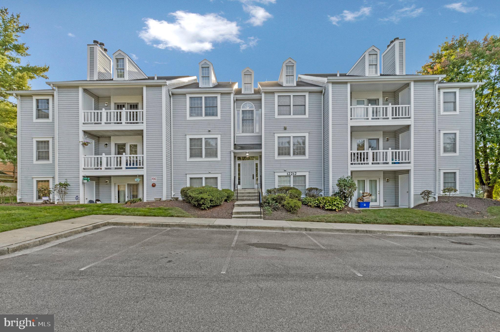 12212 Eagles Nest Court, Unit B Germantown, MD 20874 - Photo 12 of 36 a front view of a residential apartment building with a yard