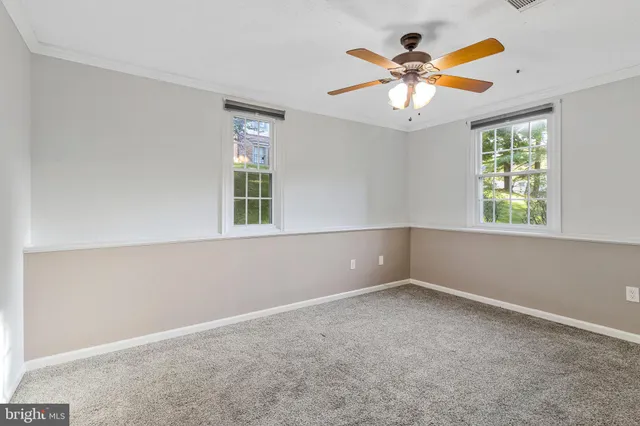 an empty room with window and ceiling fan