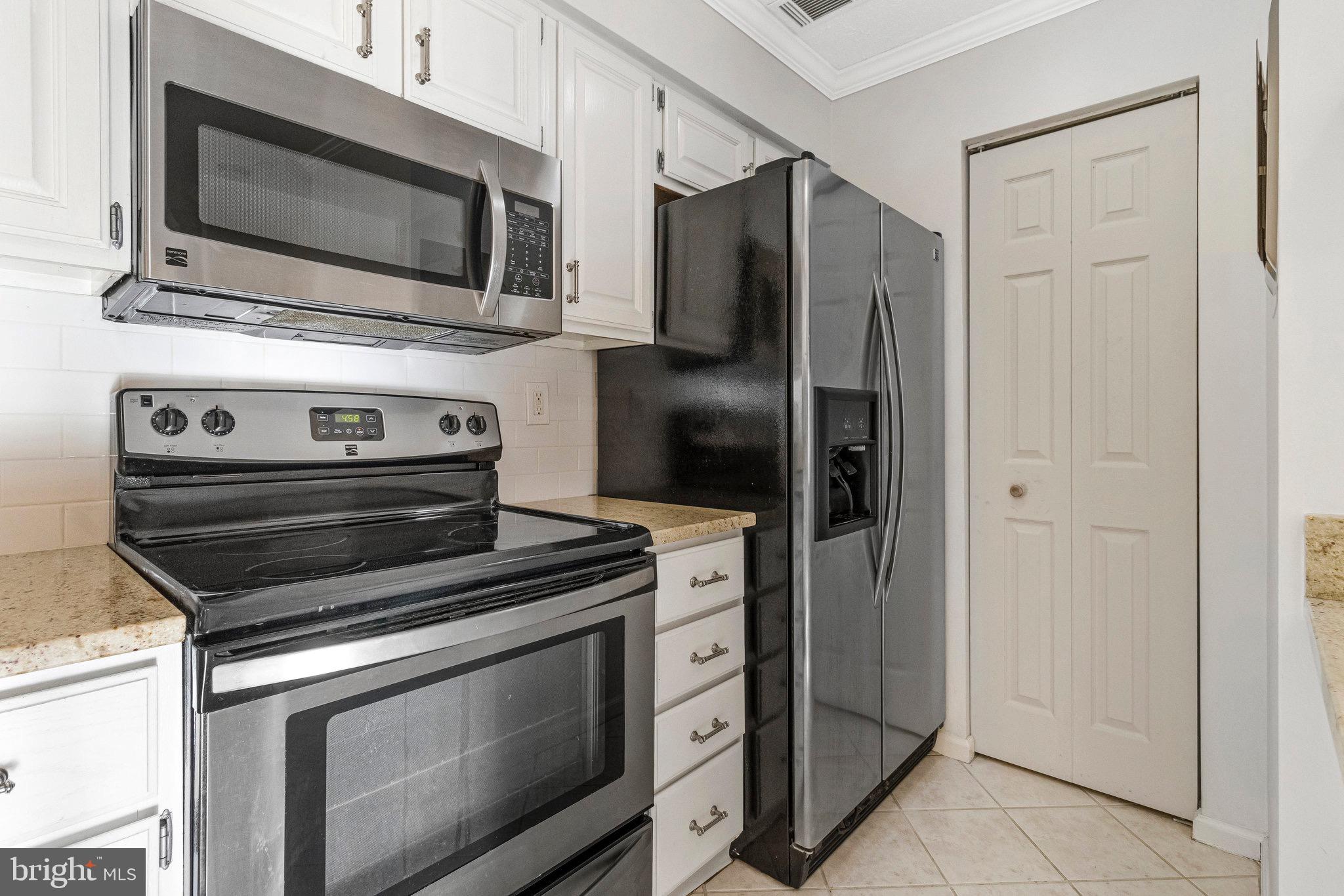 12212 Eagles Nest Court, Unit B Germantown, MD 20874 - Photo 26 of 36 a kitchen with a stove microwave and refrigerator