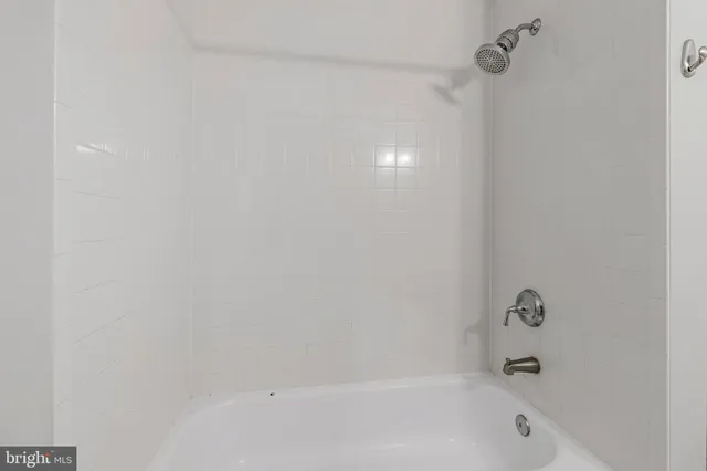 an empty room with wooden floor and a ceiling fan