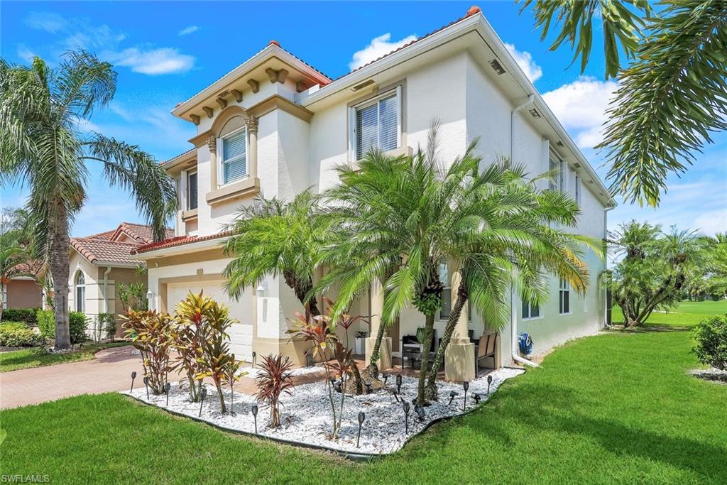 a front view of a house with a garden and trees