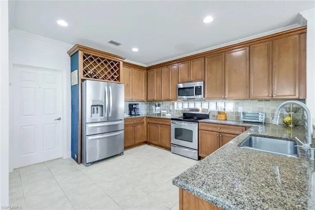 a kitchen with granite countertop stainless steel appliances and wooden cabinets