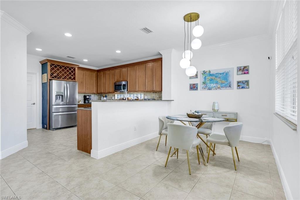 1570 Double Eagle Trail Naples, FL 34120 - Photo 15 of 50 a kitchen with stainless steel appliances granite countertop a stove a sink a refrigerator a microwave oven with white cabinets and wooden floor