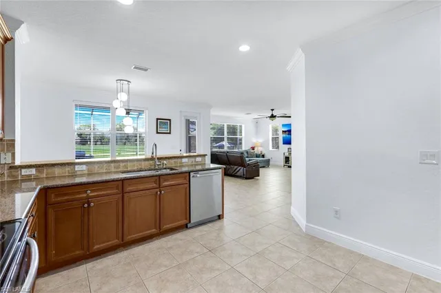 a large white kitchen with a sink and dishwasher a stove with wooden floor