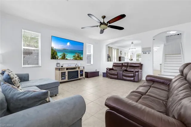 a living room with furniture kitchen view and a flat screen tv