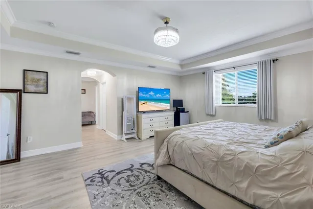 a bedroom with a bed and a chandelier