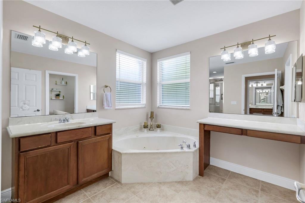 1570 Double Eagle Trail Naples, FL 34120 - Photo 26 of 50 a bathroom with a tub a sink double vanity and a mirror