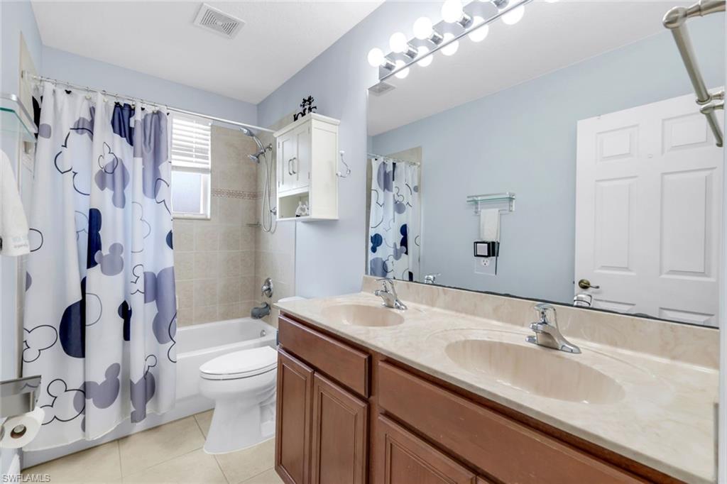 1570 Double Eagle Trail Naples, FL 34120 - Photo 29 of 50 a bathroom with a sink a toilet and a large mirror