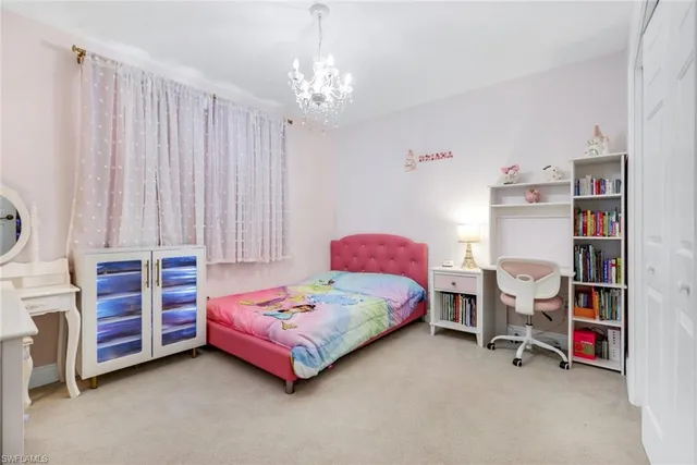 a bedroom with bed and a chandelier