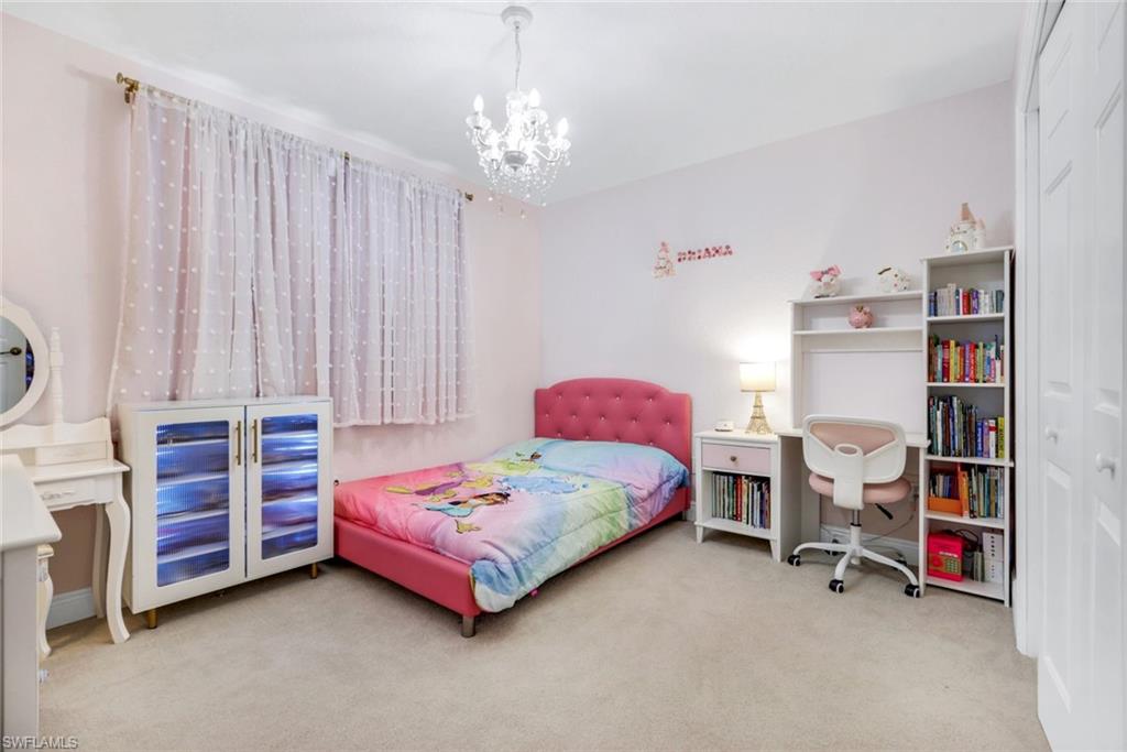 1570 Double Eagle Trail Naples, FL 34120 - Photo 33 of 50 a bedroom with bed and a chandelier