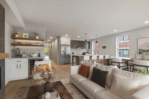 a living room with furniture kitchen view and a window