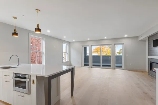 a view of a kitchen with a sink and dishwasher a oven with wooden floor