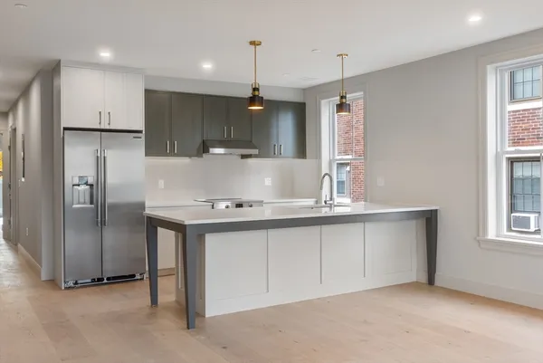 a kitchen with kitchen island a sink stainless steel appliances and window